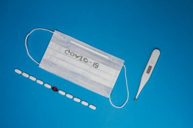 Coronavirus salgını Coronavirus 2019 hastalığı, COVID 19, nCoV, WUHAN virüsü konsepti mavi arka planda. Üzerinde COVID 19 yazan mavi bir yüz maskesi. Yazılı tıbbi koruyucu maske..