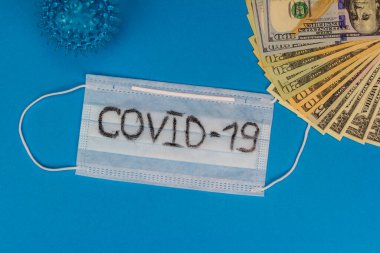 Coronavirus salgını Coronavirus 2019 hastalığı, Covid 19, ncov, mavi arka planda Wuhan virüsü konsepti. Mavi yüz maskesi ve para. Dolarlı tıbbi koruyucu maske..