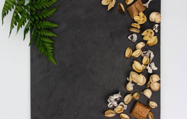 Koyu dokulu arka planda yeşil Asplenium yapraklı kurumuş aroma çiçekleri. Siyah arkaplandaki Aromatik Çiçek Parfümü.