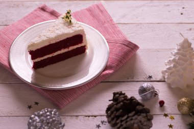 Ahşap arka plan ve Aralık kırmızı kumaş üzerine plaka üzerinde Noel kek