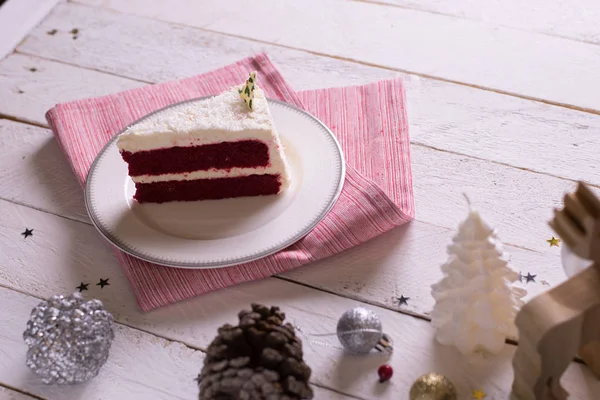 Christmas cake on plate on red fabric on wood background and dec — Stock Photo, Image