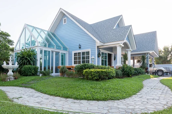 Helles blaues Haus im Sonnenlicht mit bunten Mohnblumen und etwas Grazie — Stockfoto