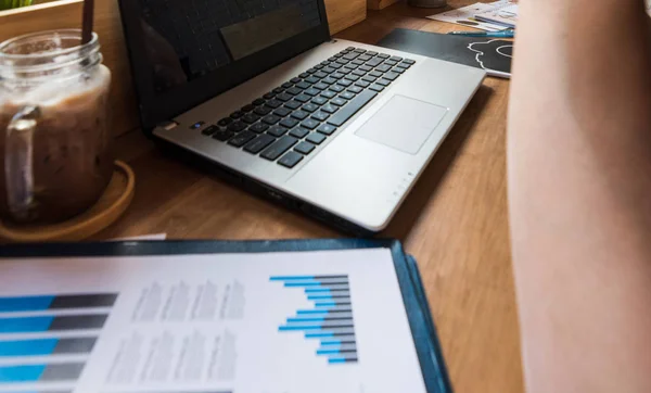 Coffee Cup op een tafel met laptob en grafiek Finance diagram in Stockfoto