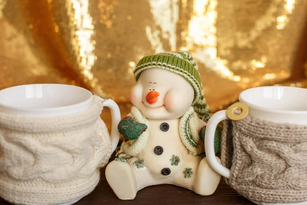 Winter drink, snowman holding two cups of coffee. Winter morning