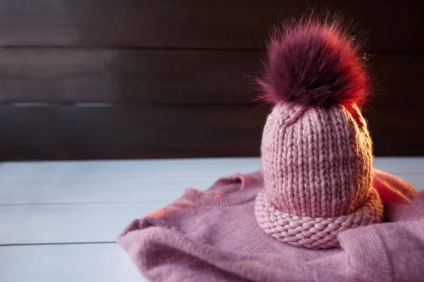 Winter. Knitted pink hat with fur on pink knitted sweater with copy space for your text about knitting. Knitted warm winter wear — Stock Photo, Image