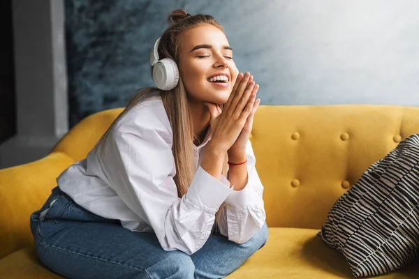 Genç bir bayan kulaklıkla müzik dinliyor. Sosyal medyada ve internet hesaplarında ses yayını ve paylaşımı.