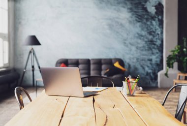 Tahta bir sandalyenin üstünde oturan bir dizüstü bilgisayar.