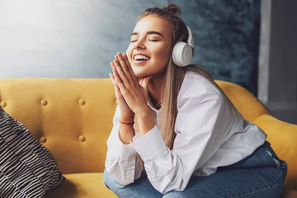 Genç bir bayan kulaklıkla müzik dinliyor. Sosyal medyada ve internet hesaplarında ses yayını ve paylaşımı.
