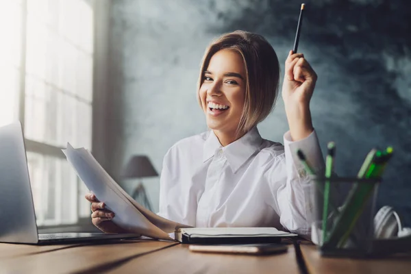 Feliz jovencita sentada en el escritorio y estudiando. Estudiante preparándose para clases universitarias. Educación a distancia . — Foto de Stock