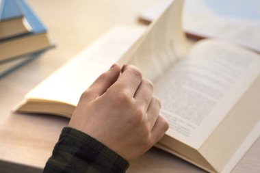 Kitap okuyorum. Ev ve eğitim masada oturan genç çocuk.