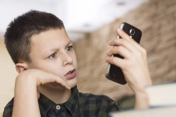 Rapaz confuso a olhar para o seu telefone inteligente. Telemóvel Conversa Conce — Fotografia de Stock