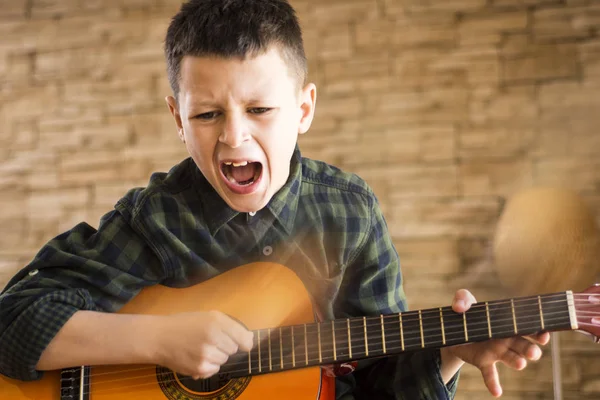 Yüksek sesle Livi içinde akustik gitar çalarken genç çocuk şarkı