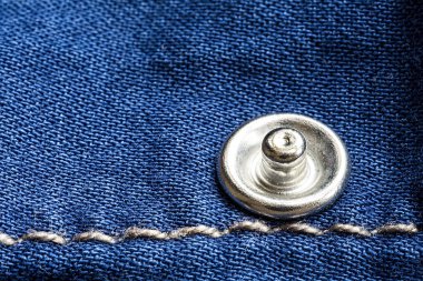 Kot doku perçin ve iplik ile kapatın. Mavi Denim kumaş arka plan.