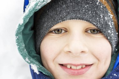 Kış karda oynarken yüz gülümseyen mutlu çocuk 