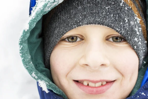 Kış karda oynarken yüz gülümseyen mutlu çocuk 