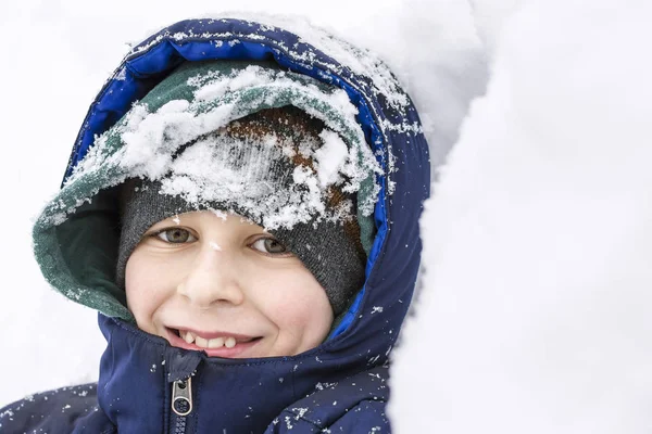 Kış karda oynarken yüz gülümseyen mutlu çocuk 