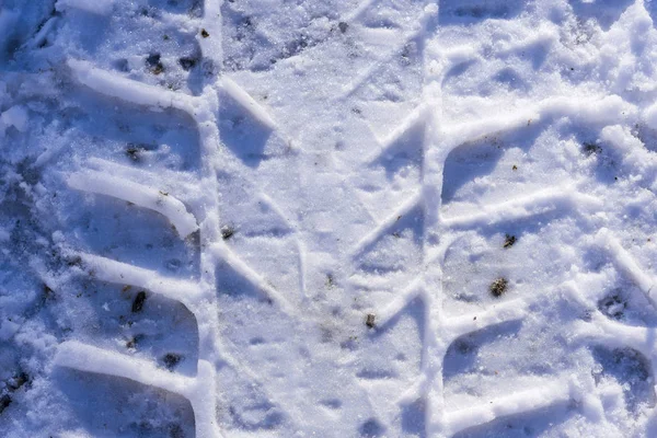 Rueda de impresión en la nieve. Rastros de las ruedas en el fondo de nieve . —  Fotos de Stock