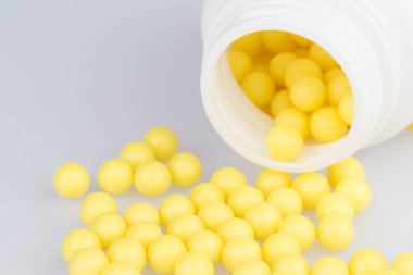 Dağınık sarı kapsayıcıyla closeup hap