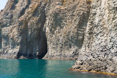 Dağ yeşil su üstünde büyük mağara ile