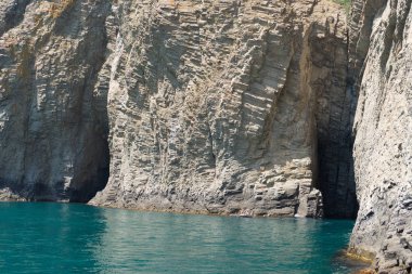 Dağ yeşil su üstünde iki mağara ile