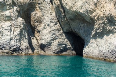 The mountain with cave above the green water