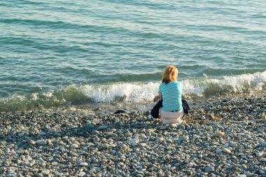 İnsanlar sahilde oturuyor.