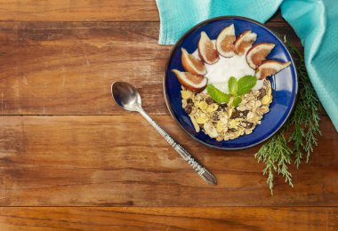 Sağlıklı kahvaltı ile müsli, yoğurt ve incir ahşap tablo
