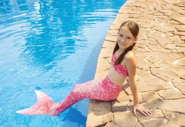 Sirena chica con cola rosa en la roca a orillas de la piscina — Foto de Stock