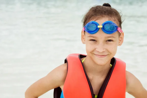Feliz niña preadolescente en chaleco salvavidas y gafas de natación contra blu — Foto de Stock