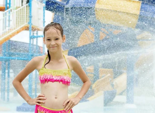 Sonriente niña preadolescente de pie bajo gotas de agua. Aguada borrosa —  Fotos de Stock