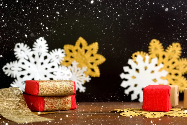 Червоні та золоті різдвяні подарункові коробки зі сніжинками на чорному фоні — стокове фото