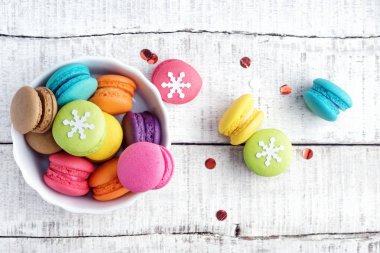 Beyaz ahşap masa üzerinde Noel dekorasyonu ile canlı renkler macarons