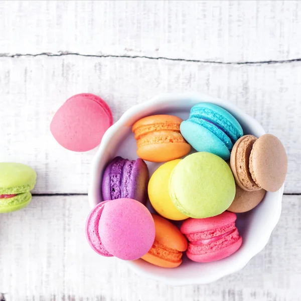 Beyaz ahşap masa üzerinde renkli macarons