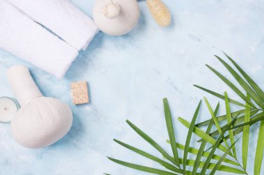Üstten Görünüm spa arka plan yat: Tay masajı çanta, havlu ve palmiye yaprakları üzerinde mavi arka plan. Sağlıklı bir yaşam tarzı. Metin alanı