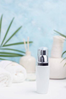 Spa arka plan: Tay masajı çanta, kozmetik, havlu ve palmiye yaprakları üzerinde mavi arka plan. Sağlıklı bir yaşam tarzı. Metin alanı