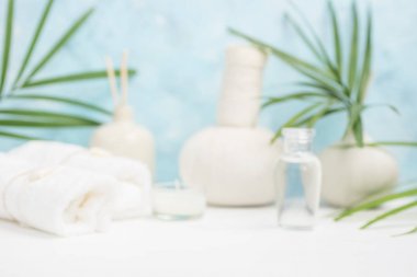 Spa arka plan: Tay masajı çanta, kozmetik, havlu ve palmiye yaprakları üzerinde mavi arka plan. Sağlıklı bir yaşam tarzı. Metin alanı