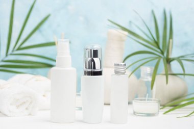 Spa arka plan: Tay masajı çanta, kozmetik, havlu ve palmiye yaprakları üzerinde mavi arka plan. Sağlıklı bir yaşam tarzı. Metin alanı