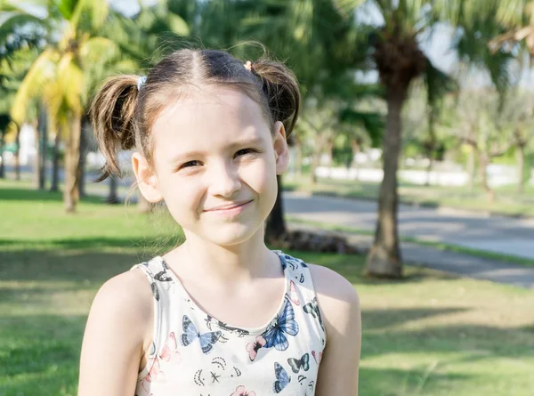 Tayland güzel portre palmiye ağaçları arasında ponytails ile küçük kız gülümsüyor. Seyahat kavramı. Metin alanı