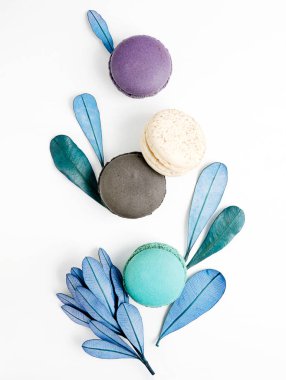 Üstten Görünüm düz renkli macarons ve mavi beyaz masa yapraklarda yatıyordu. Yaratıcı tatlı kavramı