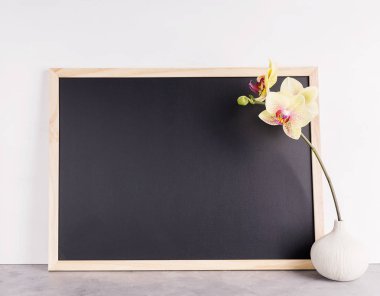 Vazoda sarı orkide ile kara tahta mockup geri. İş, iç tasarım, konsept yazı. Metin alanı