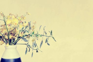 Tay Orkide woodenk plakalar parlak arka plan üzerinde mavi ve beyaz vazoda sarı. Tatil, ev iç kavramı. Metin alanı