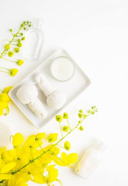 Parlak spa arka plan: mumlar ve Tay Masaj şişe ve beyaz sarı çiçekler ile bitkisel çanta. Sağlık, cilt tedavi kavramı