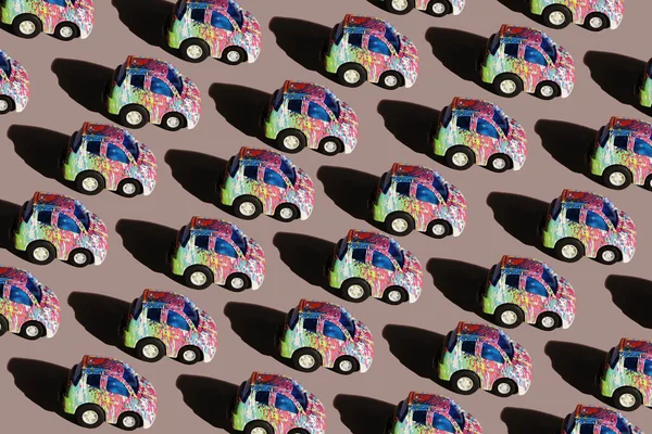 Seamless pattern of colored cars on a pink background