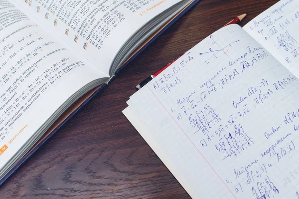 textbook and student notebook for algebra on the table