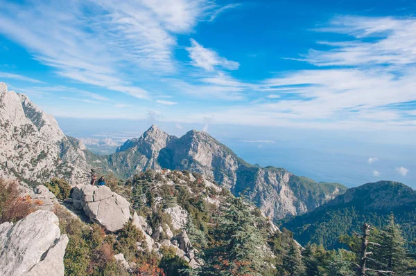 Ταξιδιώτης νεαρό ζευγάρι κάθεται στην κορυφή ενός βουνού — Φωτογραφία Αρχείου