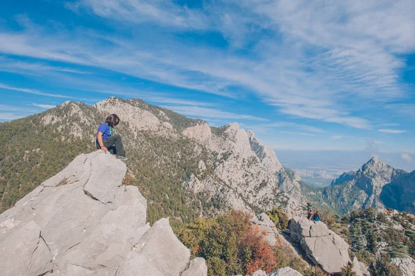 Viajante menina senta-se no topo da montanha — Fotografia de Stock