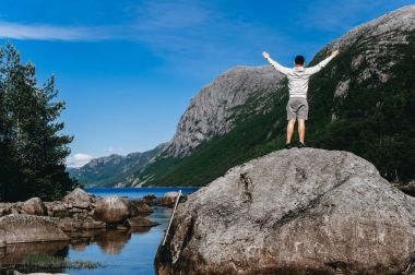 Norveç'te bir taş üzerinde yalnız bir adam duruyor
