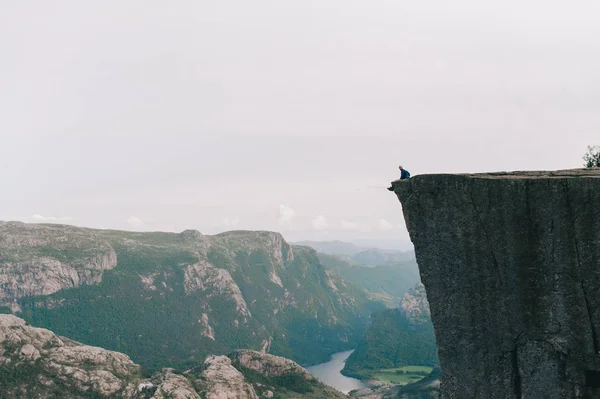 Muž sedí na okraji Preykestalen, Norsko — Stock fotografie