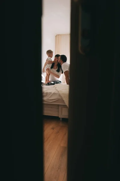 W ciąży matka całuje jej syn i ojciec przytula go — Zdjęcie stockowe