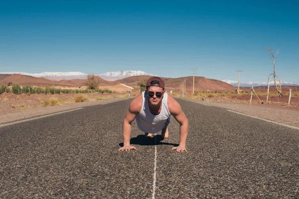 Cara esportivo na estrada no deserto — Fotografia de Stock
